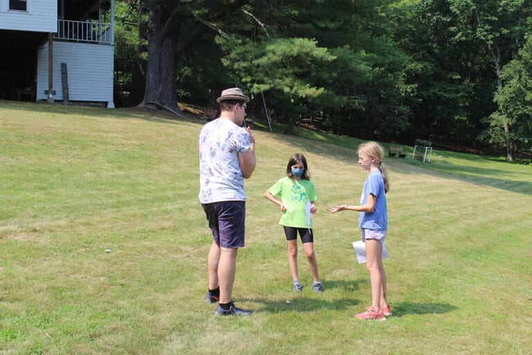 A coach is teaching a summer camp girls.