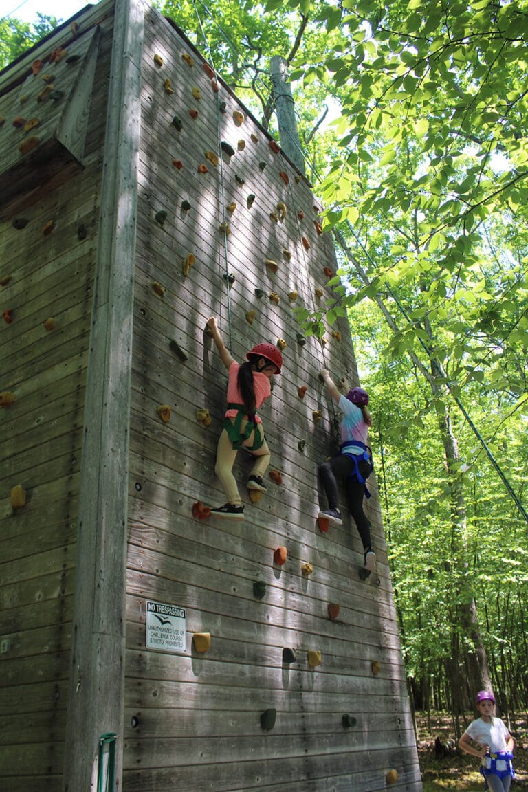 Two girls is climbing in summer camp